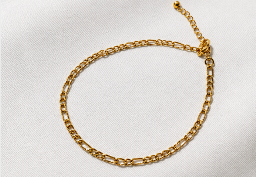 Gold chain bracelet on a light gray background